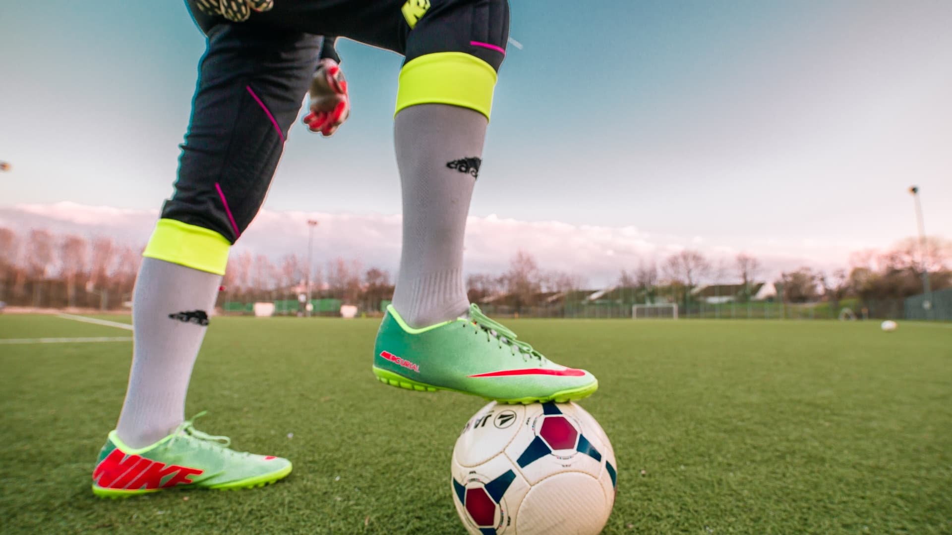 Fotballspelar med ball på grasbane